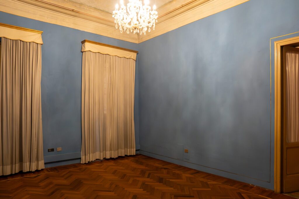 Sala azzurra di Palazzo Le Stanze a Pistoia con parquet e lampadario.