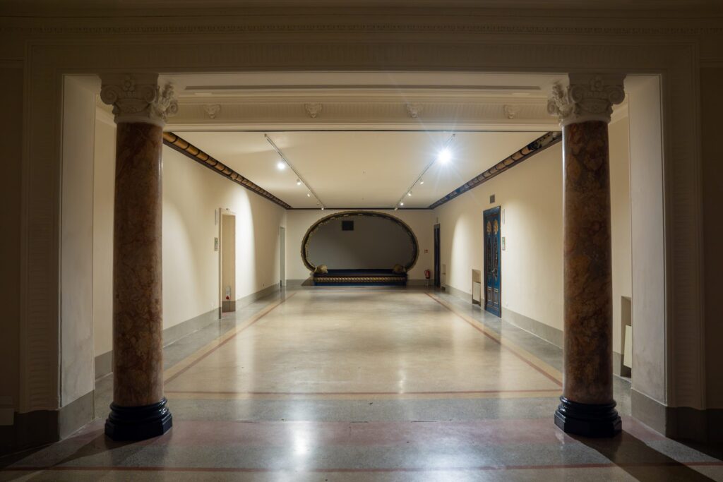 La Sala dei Pesci di Palazzo Le Stanze a Pistoia con il palco ovale per spettacoli e incontri culturali.