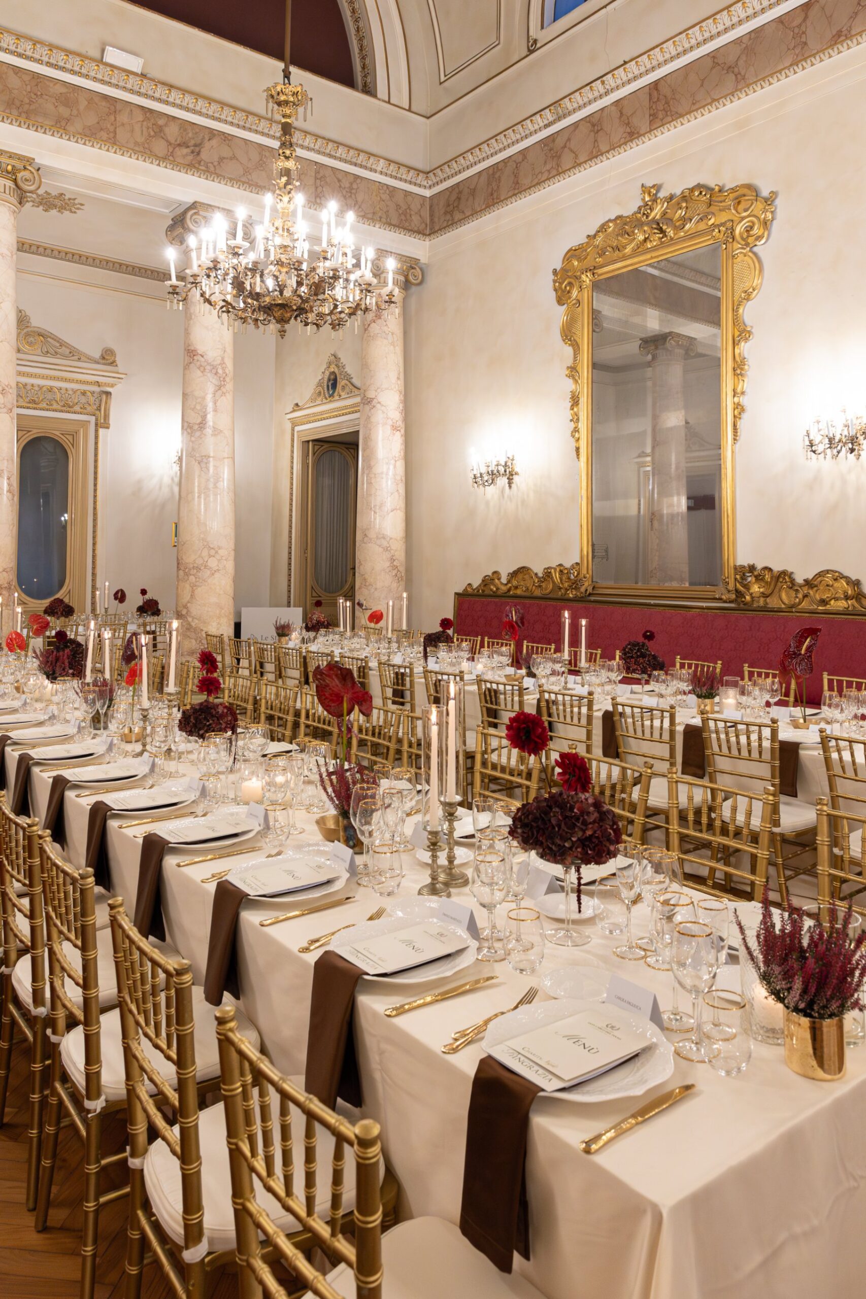 Cena di gala nel salone di Palazzo Le Stanze a Pistoia, con grande specchio dorato e tavola apparecchiata.