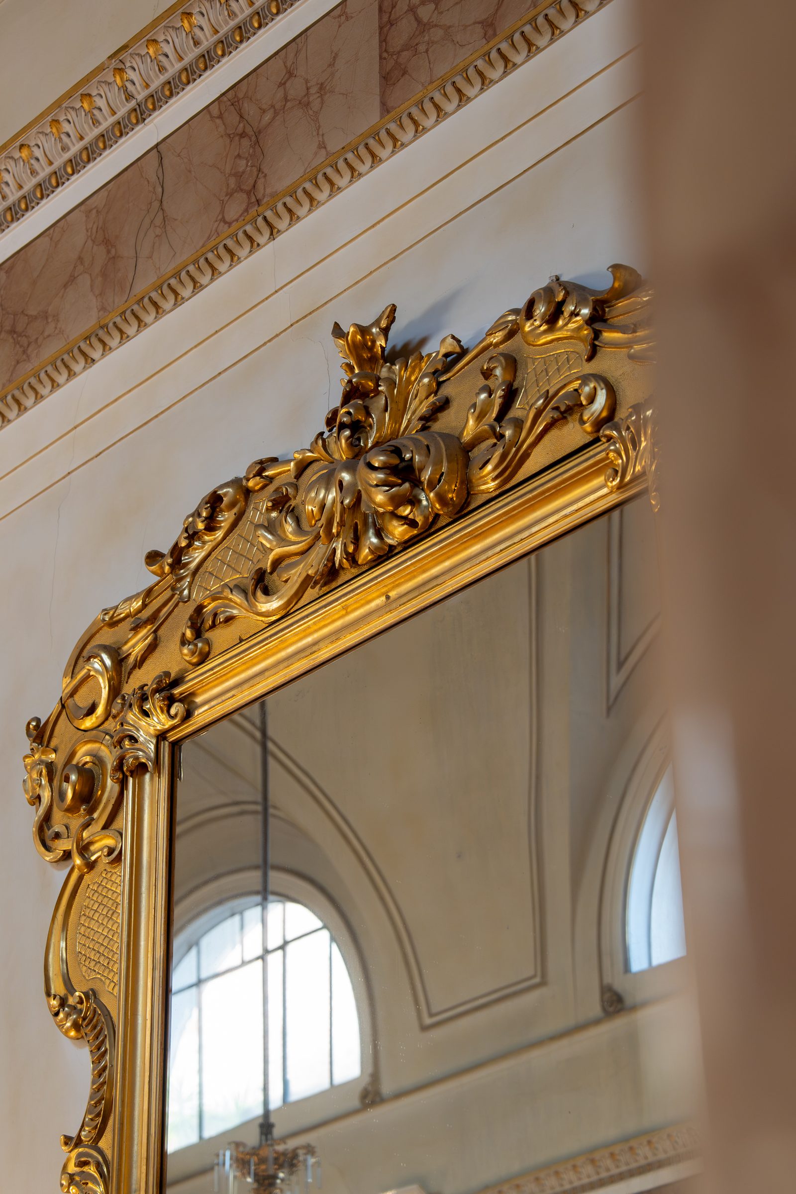 Dettaglio della cornice dorata e dello specchio nel salone di Palazzo Le Stanze a Pistoia.